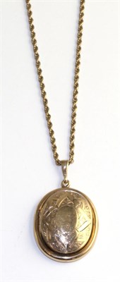 Lot 376 - A locket pendant, with chased decoration and hinged to open with a glazed interior, the reverse...