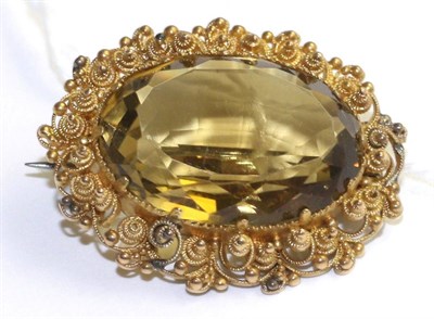 Lot 380 - A citrine brooch, an oval cut citrine in a yellow claw setting and within a cannetille and...