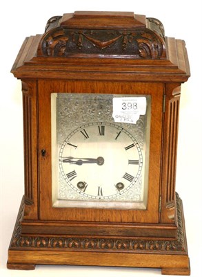 Lot 398 - An oak striking carved mantel clock, circa 1910, inverted pediment, side sound frets, silvered dial