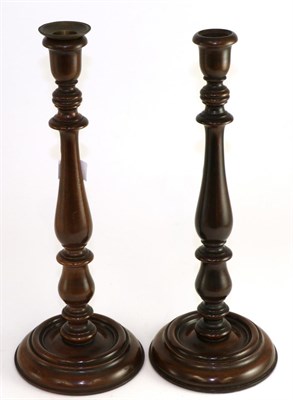 Lot 404 - A pair of 19th century turned mahogany candlesticks, 36cm