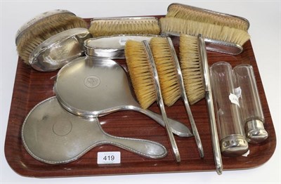 Lot 419 - Thirteen silver backed dressing table items to include seven brushes, two hand mirrors, an oval box