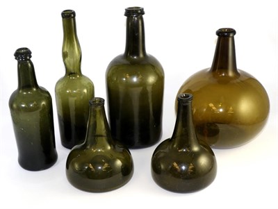 Lot 428 - A green glass wine bottle, early 18th century, of onion form, 20cm high; a similar later...