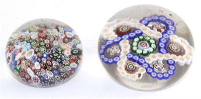 Lot 459 - A glass paperweight made up of millefiore canes, 6cm wide and a larger example made up of a...