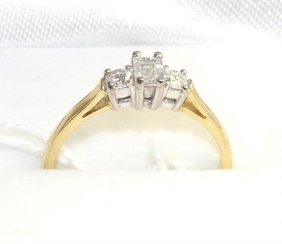 Lot 529 - An 18 carat gold diamond three stone ring, a baguette cut diamond between two round brilliant...