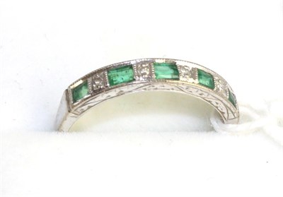 Lot 569 - An emerald and diamond ring half hoop ring, five baguette cut emeralds spaced by eight-cut diamonds