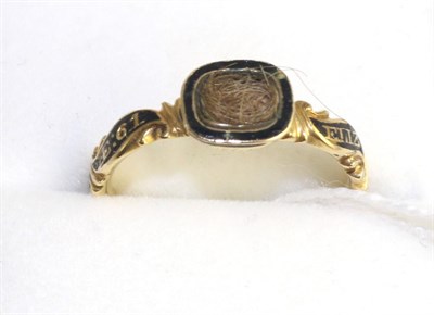 Lot 570 - A George II mourning ring, a central oval hair locket, containing hair, with a black enamel...