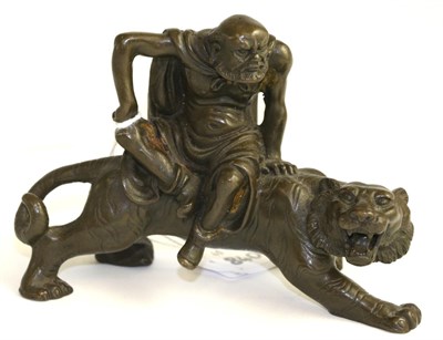 Lot 589 - A Japanese bronze figure on tiger, 8.5cm high