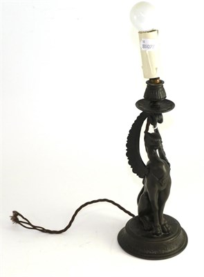 Lot 637 - A bronzed spelter candlestick, late 19th century, modelled as a griffin on a circular base,...