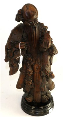 Lot 659 - Chinese rootwood figure Shoulou, 19th century, standing holding a peach, 49cm high, on a later base