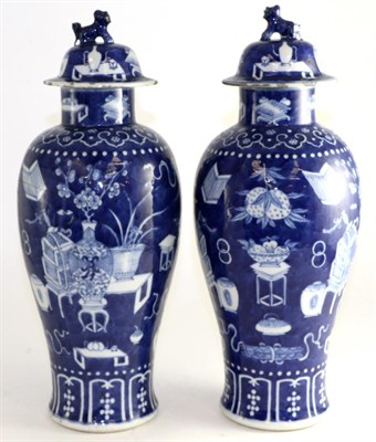 Lot 662 - A pair of Chinese porcelain baluster vases and covers, painted underglaze blue with precious...