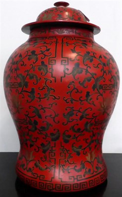 Lot 683 - A Chinese lacquer baluster vase and cover decorated with scrawling lotus on a red ground, 43cm high