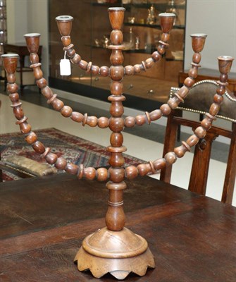 Lot 692 - A turned wood Menorah lamp, 19th century, with bobbin turned branches and column on domed base,...