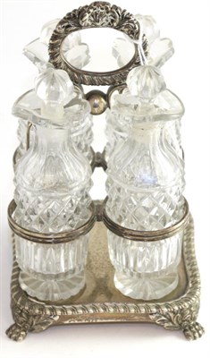 Lot 715 - A George IV silver four bottle cruet stand, London 1820, with gadrooned borders on paw feet,...