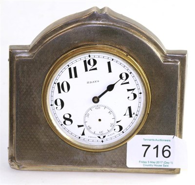 Lot 716 - A silver mounted easel backed timepiece, Sheffield 1931, with engine turned decoration, 11cm wide