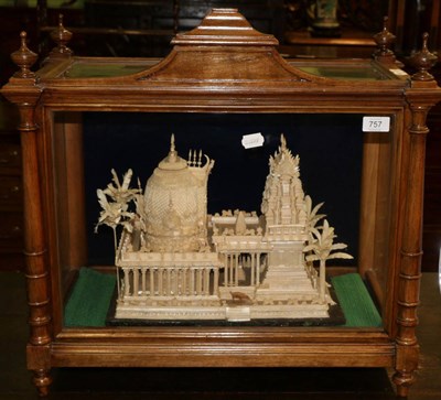 Lot 757 - An Indian balsa wood model of a temple, 19th century, flanked by palm trees, in a glazed...