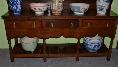 Lot 1234 - An 18th century oak low dresser, the plank top above three frieze drawers and wavy shaped apron...