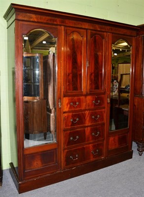 Lot 1240 - An Edwardian mahogany and boxwood strung wardrobe, with two arch mirrored doors, around two...