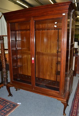 Lot 1251 - An early 20th century mahogany glazed gun cabinet, a bold cornice enclosing small shelves with...