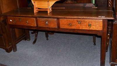 Lot 1258 - {} An 18th century joined oak side table fitted with three frieze drawers on block legs, 182cm wide