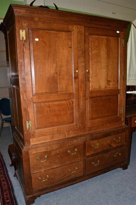 Lot 1260 - {} A George III joined oak press cupboard with two cupboard doors above four drawers, 142cm wide