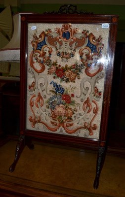 Lot 1269 - An Edwardian mahogany and inlaid fire screen containing floral needlework panel, 56cm wide