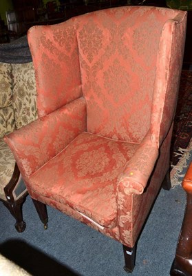 Lot 1297 - ^ A George III wingback armchair, early 19th century, recovered in salmon coloured fabric,...