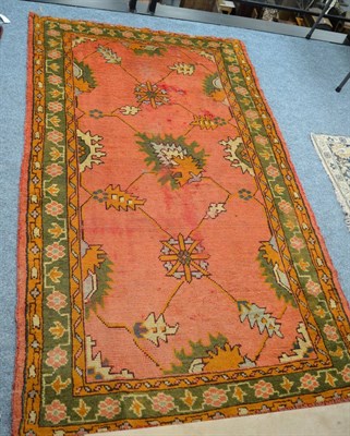 Lot 1319 - Ushak rug, Central/West Anatolia, the salmon pink field with a trellis of angular vines enclosed by