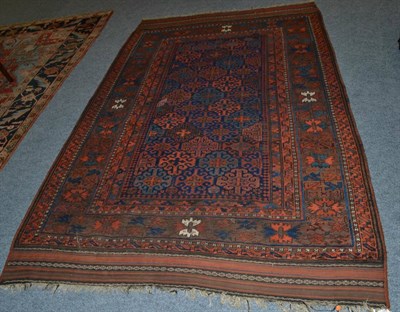 Lot 1331 - ^ A 19th century Balouch carpet, West Afghanistan, the deep indigo lattice field of hooked...