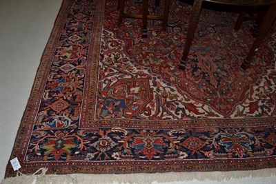 Lot 1369 - Heriz carpet, Iranian Azerbaijan, the madder field profusely decorated with vines around an...