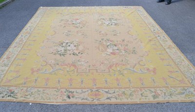 Lot 1371 - A needlepoint carpet of unusual size, China, the pale camel field with urns issuing flowers...