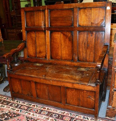 Lot 1399 - {} An early 19th century joined oak box settle with fielded back support and hinged lid, 131cm wide