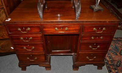 Lot 1408 - A George II mahogany knee hole desk, late 18th century, with central frieze drawer flanked by eight