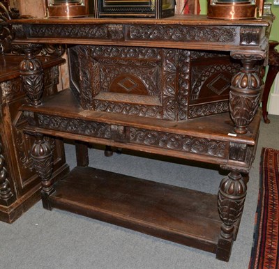 Lot 1428 - A 17th century carved oak buffet with carved bulbous supports a central cupboard drawer and...