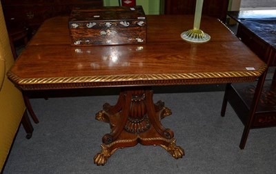 Lot 1454 - A rosewood and parcel gilt centre table, circa 1810, of rectangular canted form, the fluted...