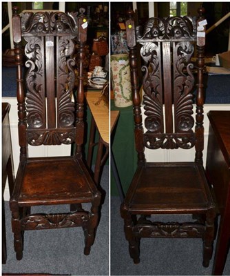 Lot 1479 - A pair of early 18th century carved oak hall chairs on spindle turned back supports above...