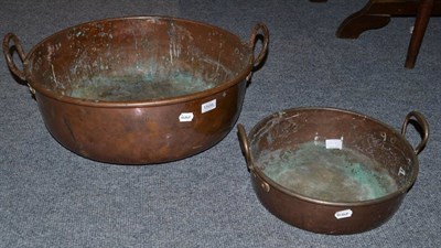 Lot 1509 - A large copper twin-handled preserving pan stamped Trin. Coll.Ko3, 59cm and another twin...