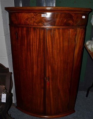 Lot 1546 - A George III mahogany bow front corner cupboard, 118cm high