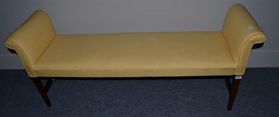 Lot 1548 - ^ A late George III scroll end window seat upholstered in yellow fabric, raised on square...