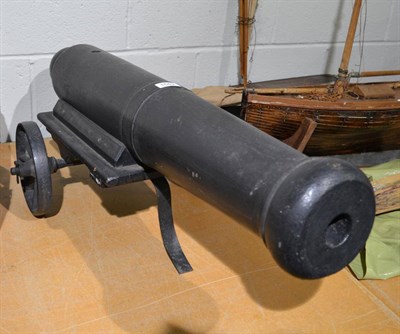 Lot 1549 - A wooden ornamental canon with iron wheels, 84cm long