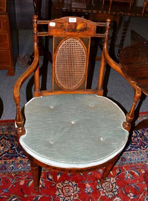 Lot 1604 - An Edwardian satinwood armchair in Neo-Classical style, with caned seat and green velvet squab...