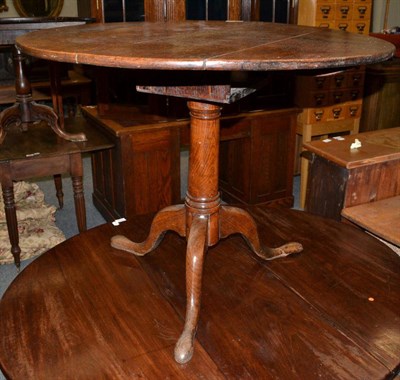 Lot 1609 - {} An 18th century oak bird cage platform tripod table on a gun barrel support, 90cm wide