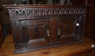 Lot 1638 - {} An oak wall cabinet with a bold cornice above a fluted frieze and two cupboard doors, 104cm wide