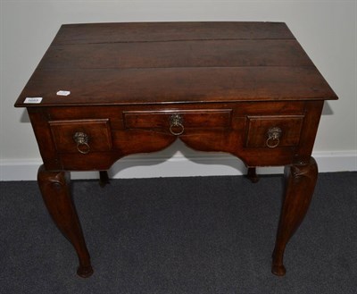 Lot 1685 - {} An 18th century oak lowboy with three frieze drawers raised on stout cabriole legs (feet...