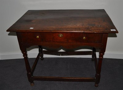 Lot 1693 - {} An 18th century joined oak table fitted with frieze drawer, raised on baluster turned legs, 91cm