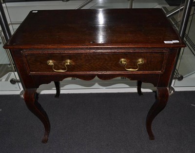 Lot 1698 - {} An oak lowboy with frieze drawer raised on cabriole legs, 18th century and later, 83cm wide