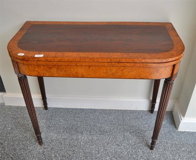 Lot 1721 - A George III burr walnut and mahogany fold over card table, raised on reeded tapered legs to...