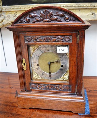 Lot 1731 - An oak chiming table clock, circa 1910, arched pediment, later side frets, 6-inch brass dial with a