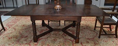 Lot 1733 - A Marsh Jones & Cribb oak dining table, with two extra leaves, on four turned legs, joined by a...