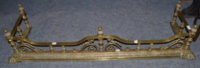 Lot 1761 - A Victorian brass fire curb, with a spindle supported rail moulded with paw feet, 140cm wide