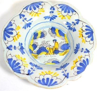 Lot 1 - A Delft fluted dish, circa 1680, painted in blue manganese and orchre in Chinese transitional style